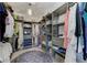 Spacious walk-in closet with custom shelving, hanging rods, drawers, and a decorative blue rug at 8963 Fishermens Bay Dr, Sarasota, FL 34231
