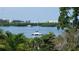 Scenic water view featuring boats sailing on a serene waterway with lush greenery and distant buildings at 8963 Fishermens Bay Dr, Sarasota, FL 34231