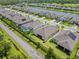 Aerial view of the back of a home, showcasing a well-maintained lawn, landscaping, and neighborhood lake at 926 Fernleaf Run, Bradenton, FL 34212
