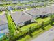 Aerial of the back of the home with a screened patio, well-maintained lawn, and lush landscaping at 926 Fernleaf Run, Bradenton, FL 34212