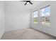 Bright bedroom features neutral carpet, ceiling fan, and two large windows at 926 Fernleaf Run, Bradenton, FL 34212