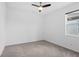 Carpeted bedroom with ceiling fan, window, and neutral walls providing a cozy and serene atmosphere at 926 Fernleaf Run, Bradenton, FL 34212