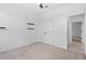 Bedroom featuring neutral carpet, floating shelves, closet and doorway at 926 Fernleaf Run, Bradenton, FL 34212