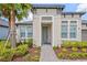 Inviting entrance with a blue front door, decorative columns, and manicured landscaping at 926 Fernleaf Run, Bradenton, FL 34212