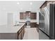 Modern kitchen with stainless steel appliances, an island with sink, and tile flooring at 926 Fernleaf Run, Bradenton, FL 34212