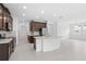 Open kitchen with island, stainless steel appliances, tile floors, and dark cabinets at 926 Fernleaf Run, Bradenton, FL 34212