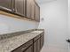 Laundry room features sleek cabinets, granite countertops, and a convenient sink for added functionality at 926 Fernleaf Run, Bradenton, FL 34212