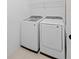 Functional laundry room with modern washer and dryer and wire shelving, maximizing space and efficiency at 926 Fernleaf Run, Bradenton, FL 34212