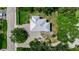 Aerial view of a home with a silver roof, surrounded by lush landscaping and a circular driveway at 105 Shore Rd, Nokomis, FL 34275