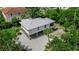Gorgeous home with a metal roof, wooden garage doors and an exterior staircase, surrounded by lush greenery at 105 Shore Rd, Nokomis, FL 34275