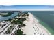 Panoramic aerial shot of a beach with cars, sand, clear water and people enjoying the outdoors at 105 Shore Rd, Nokomis, FL 34275
