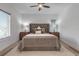 Comfortable bedroom featuring a gray bed with tufted headboard and ceiling fan at 105 Shore Rd, Nokomis, FL 34275
