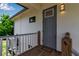 Charming front entrance with a gray front door, wooden deck, and stylish light fixture at 105 Shore Rd, Nokomis, FL 34275