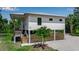 Stunning elevated home featuring a modern design, a wooden fence and staircase and a well-manicured lawn at 105 Shore Rd, Nokomis, FL 34275