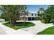Exterior view of an elevated home surrounded by lush greenery and a spacious driveway at 105 Shore Rd, Nokomis, FL 34275