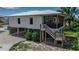 Exterior elevated home showcasing a staircase and a screened in porch at 105 Shore Rd, Nokomis, FL 34275