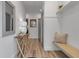 Inviting foyer with a bench, coat hooks, a stylish table, and light wood flooring at 105 Shore Rd, Nokomis, FL 34275