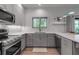 Well-lit kitchen features quartz counters, stainless appliances, gray cabinetry, and easy access to an outdoor deck at 105 Shore Rd, Nokomis, FL 34275