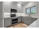 Charming kitchen featuring gray cabinets, stainless steel appliances, and bright countertops, offering modern convenience at 105 Shore Rd, Nokomis, FL 34275