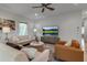 Bright living room features neutral furniture, a ceiling fan, and a large television at 105 Shore Rd, Nokomis, FL 34275