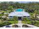 Aerial view of a large community pool with a clubhouse and palm trees at 10611 Ladybug Cv, Parrish, FL 34219