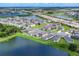 Aerial view of a neighborhood near a lake, featuring well-maintained homes and streets at 10611 Ladybug Cv, Parrish, FL 34219