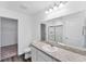 Bathroom with large mirror, speckled granite vanity, and view into walk-in closet at 10611 Ladybug Cv, Parrish, FL 34219
