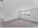 Bright bedroom featuring neutral carpet, white walls, and view from double window at 10611 Ladybug Cv, Parrish, FL 34219