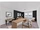 Modern home office with black accent wall, large desk, and views of the outdoors at 10611 Ladybug Cv, Parrish, FL 34219