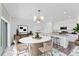 Stylish kitchen and dining area with a modern island, quartz countertops, and a chic chandelier at 10611 Ladybug Cv, Parrish, FL 34219