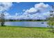 Scenic view of a tranquil pond bordered by green lawn and neighborhood homes at 10611 Ladybug Cv, Parrish, FL 34219