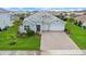 Aerial view of the home showcasing its well-manicured lawn, beautiful landscaping, and a three-car garage at 12139 Cranston Way, Bradenton, FL 34211