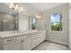 Bright bathroom featuring double sinks, white cabinetry, and wood-look tile flooring at 12139 Cranston Way, Bradenton, FL 34211