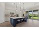 Modern kitchen with a large center island, stainless steel appliances, and sliding doors to the lanai at 12139 Cranston Way, Bradenton, FL 34211