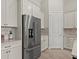 Elegant kitchen featuring stainless steel refrigerator and white cabinets at 12139 Cranston Way, Bradenton, FL 34211
