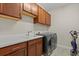 Well-equipped laundry room with stylish cabinets, sleek countertops, and modern washer and dryer at 12139 Cranston Way, Bradenton, FL 34211