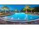 Stunning pool area with crystal-clear blue water, palm trees, lounge seating, and beautiful landscaping at 12139 Cranston Way, Bradenton, FL 34211