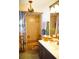 Bathroom with chandelier, colorful shower curtain, blue vanity and gold hardware at 1505 43Rd Avenue W Dr, Palmetto, FL 34221