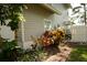 Side of home featuring colorful landscaping and a walkway leading to a white fenced area at 1505 43Rd Avenue W Dr, Palmetto, FL 34221