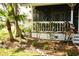 Charming screened front porch surrounded by lush tropical landscaping, including palm trees and flowering shrubs at 1505 43Rd Avenue W Dr, Palmetto, FL 34221