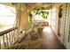 Inviting porch area with brick flooring and multiple seating options including a porch swing at 1505 43Rd Avenue W Dr, Palmetto, FL 34221