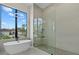 Modern bath features a soaking tub, frameless shower, a large window, and designer fixtures at 1605 Landfall Dr, Nokomis, FL 34275