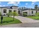 A modern home with a paver driveway and lush landscaping at 1605 Landfall Dr, Nokomis, FL 34275