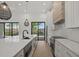Modern kitchen featuring a large island, stainless steel appliances, and sliding glass doors to backyard at 1605 Landfall Dr, Nokomis, FL 34275