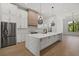 Bright, spacious kitchen featuring a large island, stainless steel appliances, and modern pendant lighting at 1605 Landfall Dr, Nokomis, FL 34275