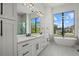 Luxurious primary bathroom with double vanity, soaking tub, walk-in shower, and large windows at 1605 Landfall Dr, Nokomis, FL 34275