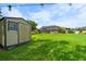 View of the backyard with a storage shed and screened-in patio at 1711 145Th E St, Sarasota, FL 34212