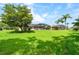 Spacious backyard with lush green grass, trees, and a screened-in patio area at 1711 145Th E St, Sarasota, FL 34212
