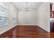 Dining room featuring hardwood floors, arched windows, modern chandelier and neutral walls at 1711 145Th E St, Sarasota, FL 34212