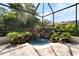 A rock waterfall feature elevates this screened pool area with beautiful plants and clear water at 1711 145Th E St, Sarasota, FL 34212